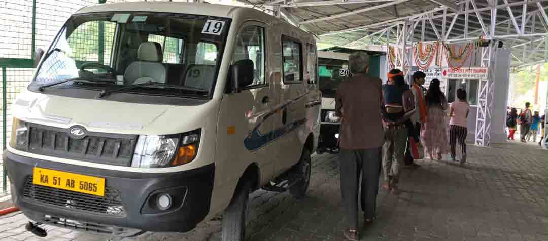 Pilgrims boarding a battery car at a yatra track boarding point